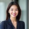 세련된 오피스룩을 입고 미소 짓는 여성.
